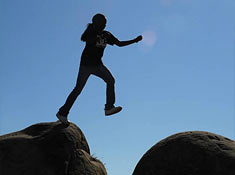 Girl leaping between rocks